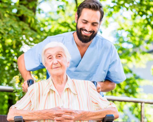 Geriatric nurse pushing senior lady in wheel chair thru home